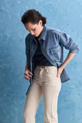 Sobrecamisa de denim de calce amplio y color azul, con cuello clásico, cierre frontal con broches metálicos y bolsillos delanteros con solapa.