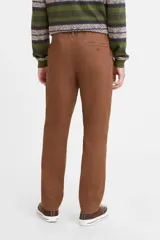 Pantalón de gabardina color marrón con cintura elástica, corte relajado en cadera y muslos, y pierna semi ajustada.