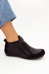 Zapato de cuero negro con doble cierre frontal, suela plana de goma con tachuelas y detalles en gamuza en la puntera y el talón.