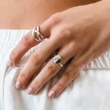 Anillo de plata con diseño de círculo y anillo de plata con diseño de líneas cruzadas.