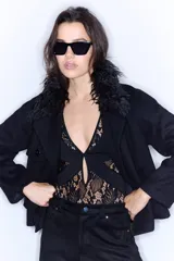 Body negro de encaje con escote en V profundo y mangas largas.