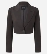 Blazer sastre de corte cropped y estructura entallada, confeccionado en tejido con estampado de cuadros. Presenta cierre frontal con un único botón, solapas clásicas y mangas largas.