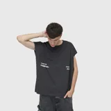 Musculosa de corte oversize color gris oscuro, con cuello redondo y estampa gráfica blanca en el frente.