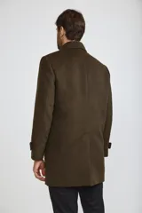 Abrigo tipo carcoat de corte clásico y estructura formal, en color azul marino. Presenta cierre frontal con botones, cuello camisero y bolsillos laterales. El interior cuenta con un forro oscuro con detalles en contraste.