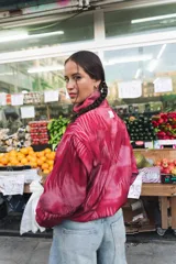 Campera con cierre frontal, cuello alto y bolsillos laterales. Estampado abstracto en tonos rojo y rosa.