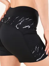 Calza corta deportiva de tiro alto, color negro, con paneles laterales estampados con diseño de mármol en blanco y negro.