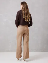 Pantalon de corte wide leg y tiro alto, con cintura estructurada, pasadores para cinturon y cierre frontal con gancho. Presenta bolsillos laterales de ojal y bolsillos traseros simulados, confeccionado en un tejido con caida fluida.