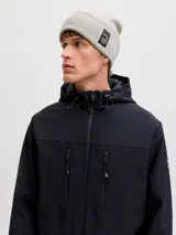 Gorro de punto tipo beanie en color gris claro, con diseño acanalado y parche rectangular con logo de la marca en la parte frontal.