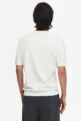 Remera de punto fino color blanco, con cuello redondo acanalado y mangas cortas, de corte slim fit.