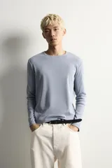 Camiseta de manga larga con cuello redondo, confeccionada en tejido con estructura de canalé y corte relajado.