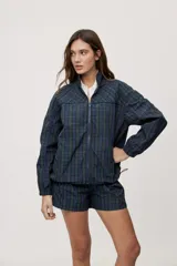 Campera liviana de calce relajado con estampado a cuadros en tonos de azul y verde. Cuenta con cuello alto, cierre frontal y mangas largas.