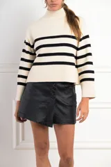 Polera de cuello alto, color blanco con rayas horizontales marrones. De calce ajustado y manga larga con puños acampanados.