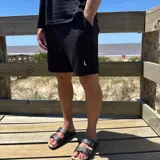 Short negro de tejido texturizado con cordón ajustable en la cintura y logo bordado en la pierna izquierda.