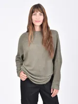 Buzo de tejido de punto tipo waffle en color verde oliva, con cuello redondo y mangas largas de corte holgado.