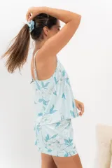 Pijama de seda estampada con diseño floral en tonos celestes y blancos. Incluye una musculosa con escote en V y espalda recta, y un short con elástico en la cintura.