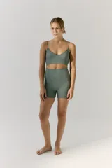 Biker deportiva de tejido seamless (sin costuras) color verde militar, con cintura alta y ancha. Presenta el logo R11 estampado en la parte trasera de la cintura.