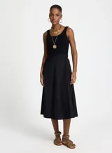 Vestido midi negro sin mangas, con corte evasé, cuello redondo y bolsillos laterales.