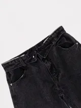 Jean de corte baggy con cintura cruzada asimétrica y diseño de tiro bajo, confeccionado en denim de color negro lavado.