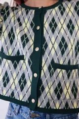 Saco de punto con diseño de rombos en tonos verde, amarillo y gris. Presenta cuello redondo, cierre frontal con botones y dos bolsillos delanteros con terminaciones en contraste.