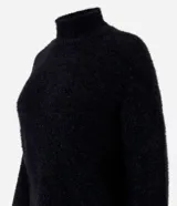 Suéter negro de punto con hilos metálicos, cuello alto y mangas largas.
