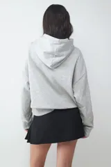 Buzo con capucha ajustable mediante cordón y bolsillo tipo canguro. Presenta mangas largas, puños y ruedo acanalados.