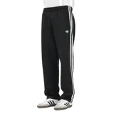 Pantalon deportivo Adidas modelo Firebird, color negro, con las icónicas tres tiras blancas laterales y logo del trébol bordado en la pierna. Presenta cintura elástica y corte recto.