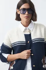 Cardigan de tejido jacquard en color azul marino y blanco, con diseño de conejitos en los laterales, cierre frontal con botones y cuello redondo.