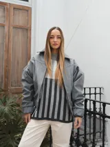 Campera gris con cierre frontal, cuello camisero y mangas largas con puños elásticos.