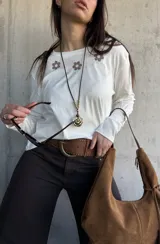Remera blanca de manga larga con detalles bordados de flores en marrón en la parte superior frontal.