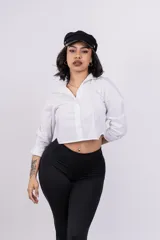Camisa blanca crop con cuello clásico, mangas largas y cierre frontal con botones.