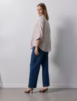 Camisa de lino marca Dash, color beige con rayas verticales blancas, cuello con solapa, cierre frontal de botones, bolsillo aplicado en el pecho y mangas largas con sistema para arremangar mediante presilla y botón.