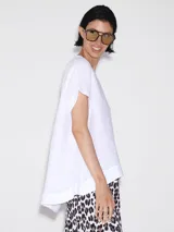 Remera blanca de lino con corte asimétrico y mangas cortas.