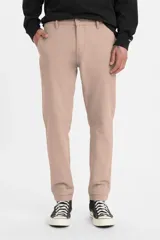 Pantalón tipo chino de corte estándar y pierna cónica, color rosa claro, con cierre de botón y cremallera, bolsillos laterales y traseros.