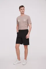 Bermuda de corte recto y diseño minimalista, confeccionada en tejido técnico de poliéster. Presenta cintura elástica con cierre de botón frontal, bolsillos laterales y un bolsillo pequeño adicional en el lateral izquierdo.