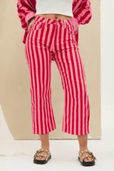Pantalón de denim de tiro medio con diseño de rayas verticales en tonos rojo y rosado, de corte recto y largo midi.