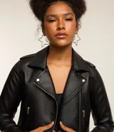 Campera biker de poliuretano color marrón oscuro, con cuello con solapas, cierre frontal de cremallera metálica, bolsillos laterales con cierre y detalles de botones a presión.