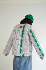 Campera corta de nylon impermeable con estampado de medusas y rayas onduladas en tonos beige y verde.