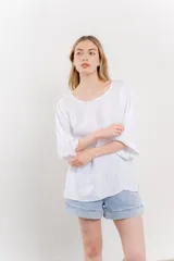 Blusa blanca de lino, con escote en V y mangas 3/4 holgadas.