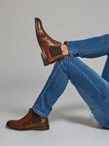 Botín de cuero color marrón con paneles laterales elásticos y suela de goma.