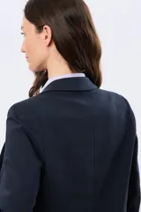 Blazer azul marino de corte entallado, confeccionado en algodón con elastano, con solapas clásicas y bolsillos frontales con solapa.