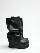 Botas negras de ecocuero con caña alta, plataforma y suela track.