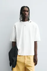 Camiseta de algodón blanca con corte relajado y cuello redondo. Presenta un pequeño bordado en negro con la palabra "BULB" en la parte superior del pecho.