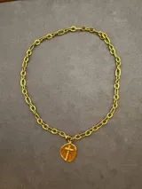 Collar de cadena de eslabones gruesos con baño de oro, que presenta un dije circular con una cruz en relieve.