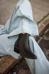 Botas tipo chelsea de cuero negro, con elásticos laterales y taco bajo cuadrado.