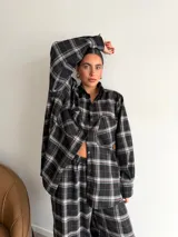 Pantalón de corte recto y holgado, confeccionado en tela de viyela con estampado de cuadros en tonos negro, gris y blanco. Presenta cintura elástica para mayor comodidad.