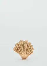 Bolso rígido estilo clutch con diseño en forma de concha de mar, acabado dorado texturizado. Cuenta con asa larga de cadena y forro interior.