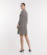 Vestido chemise midi de viscosa con estampado geométrico en blanco y negro. Tiene lazo en el cuello, abotonadura frontal y mangas 3/4.