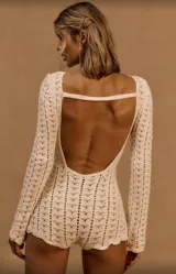 Conjunto de dos piezas tejido en crochet color crudo, compuesto por una remera de manga larga y un short de tiro alto. El diseño presenta un patrón de punto calado y ajuste al cuerpo.