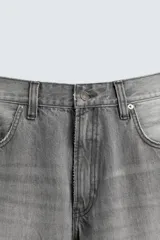 Jeans de hombre, corte balloon fit, tiro medio, confeccionados en denim rígido de algodón. Presentan un efecto lavado con un marcado degradado vertical, cinco bolsillos y cierre frontal con cremallera y botón.