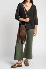 Sweater de punto con acabado brillante, cuello en V y mangas tres cuartos. Presenta un diseño holgado y tejido traslúcido.